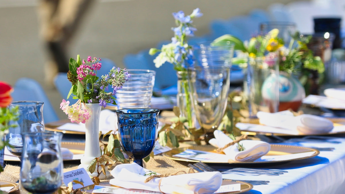 Elegant table setting with colorful glassware and fresh flowers for a special event.