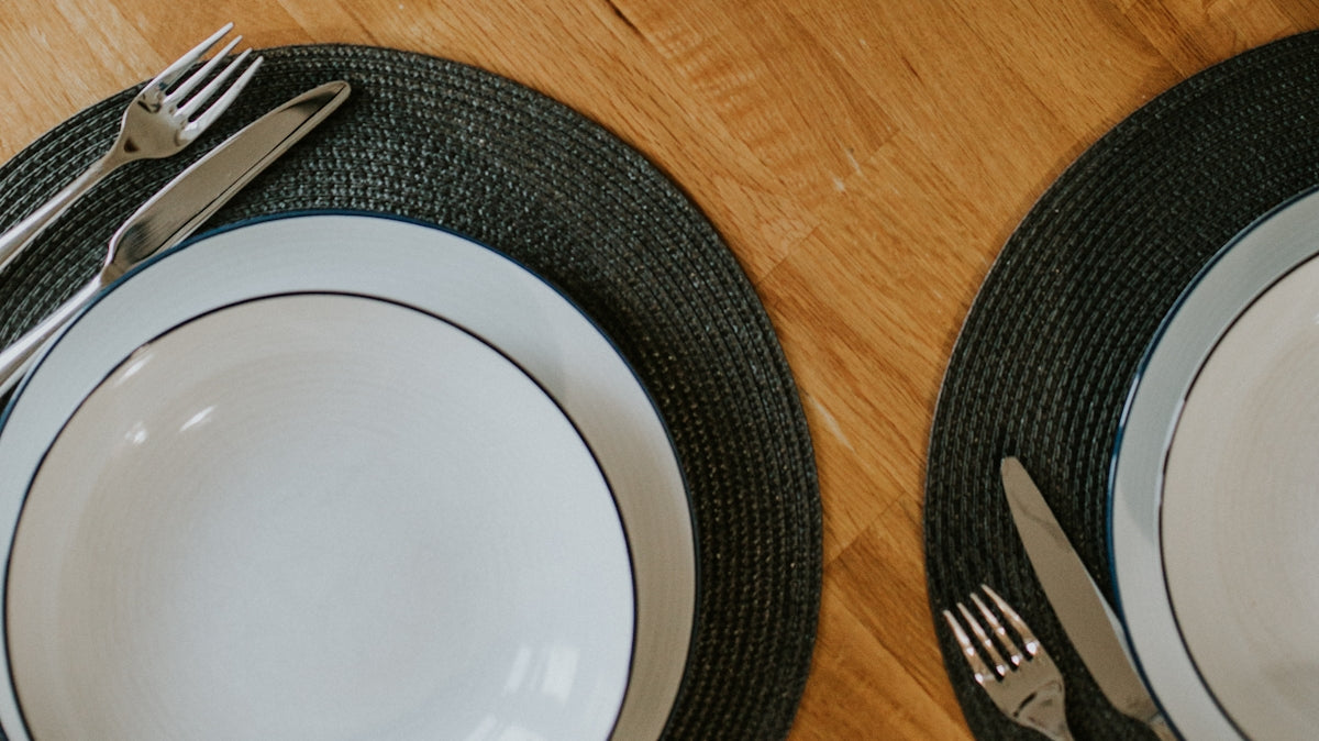 white round plate beside silver fork and knife