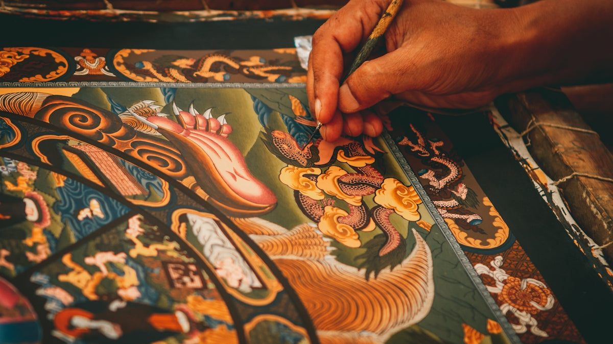 a person holding a pencil and drawing on a piece of art