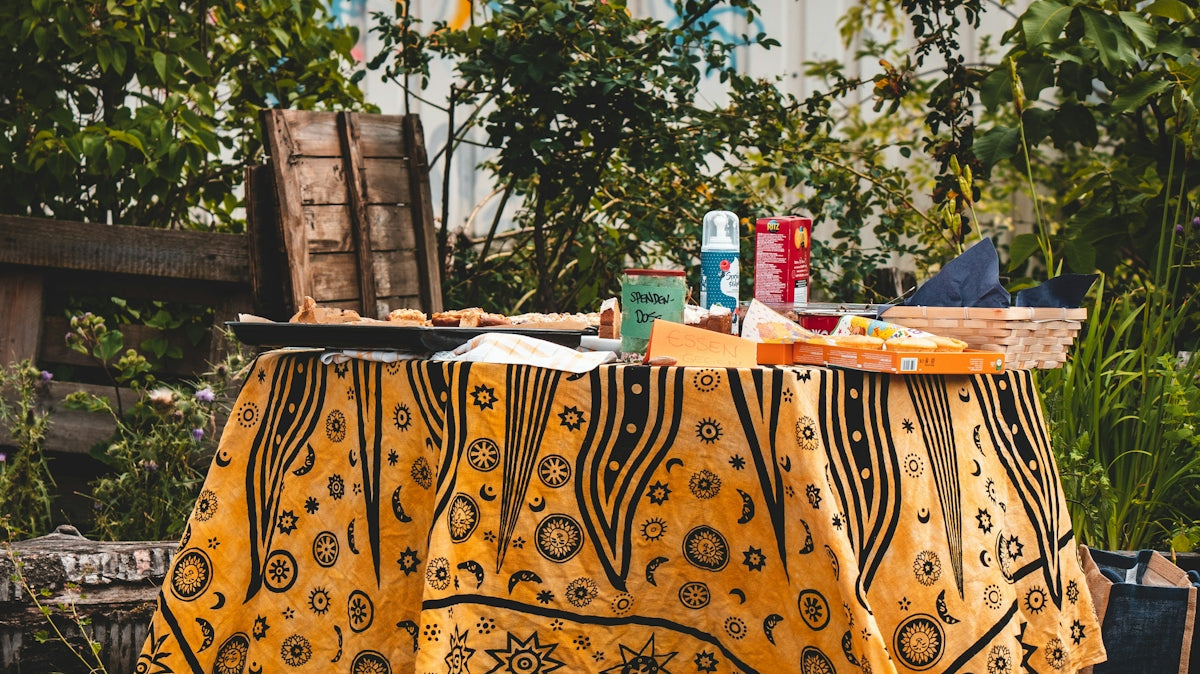 a table with a yellow cloth and a basket of food on it