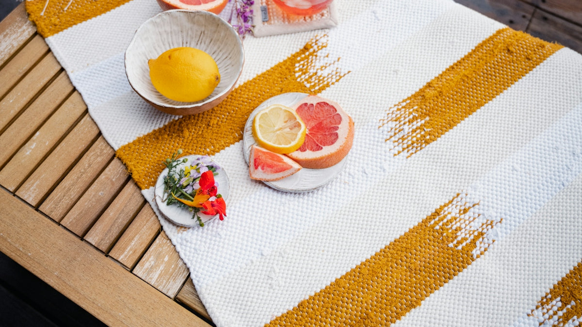 a table topped with a bowl of fruit next to a bowl of oranges