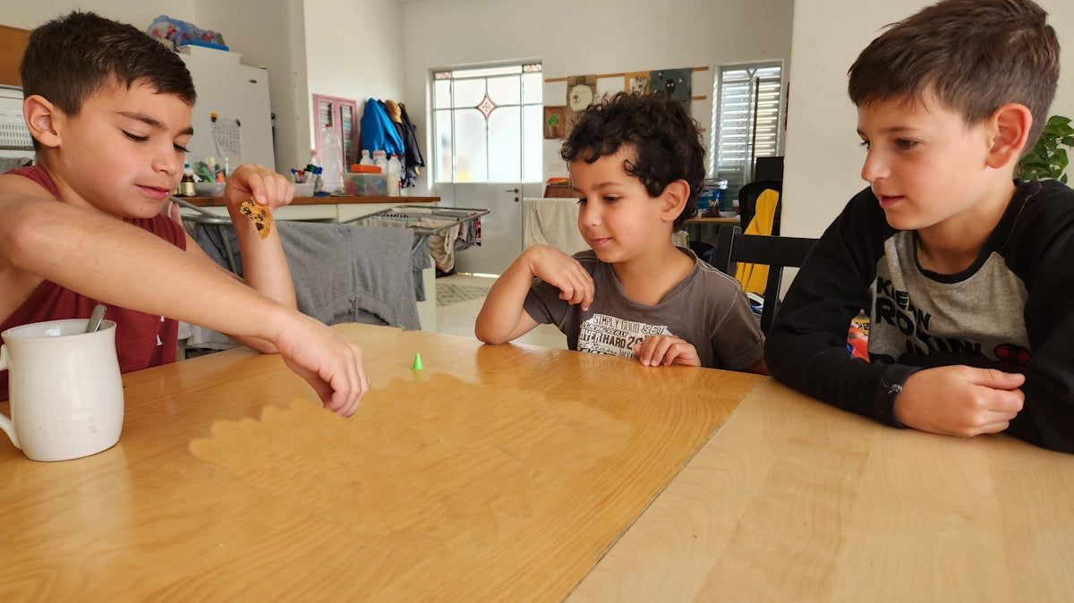 a group of young boys sitting around a wooden table