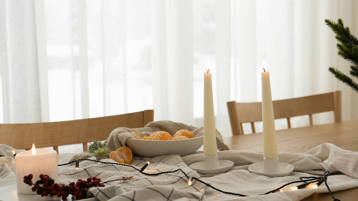 a wooden table topped with candles next to a christmas tree