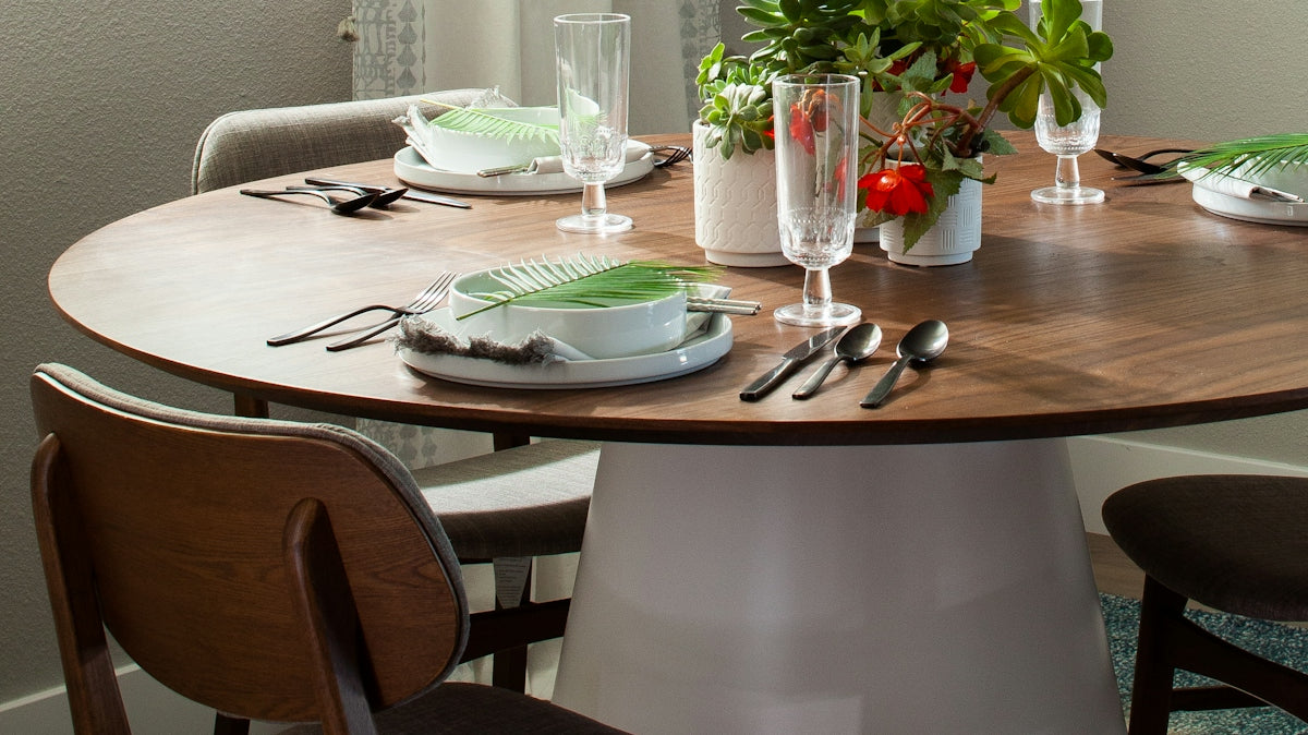 a dining room table with chairs and a potted plant