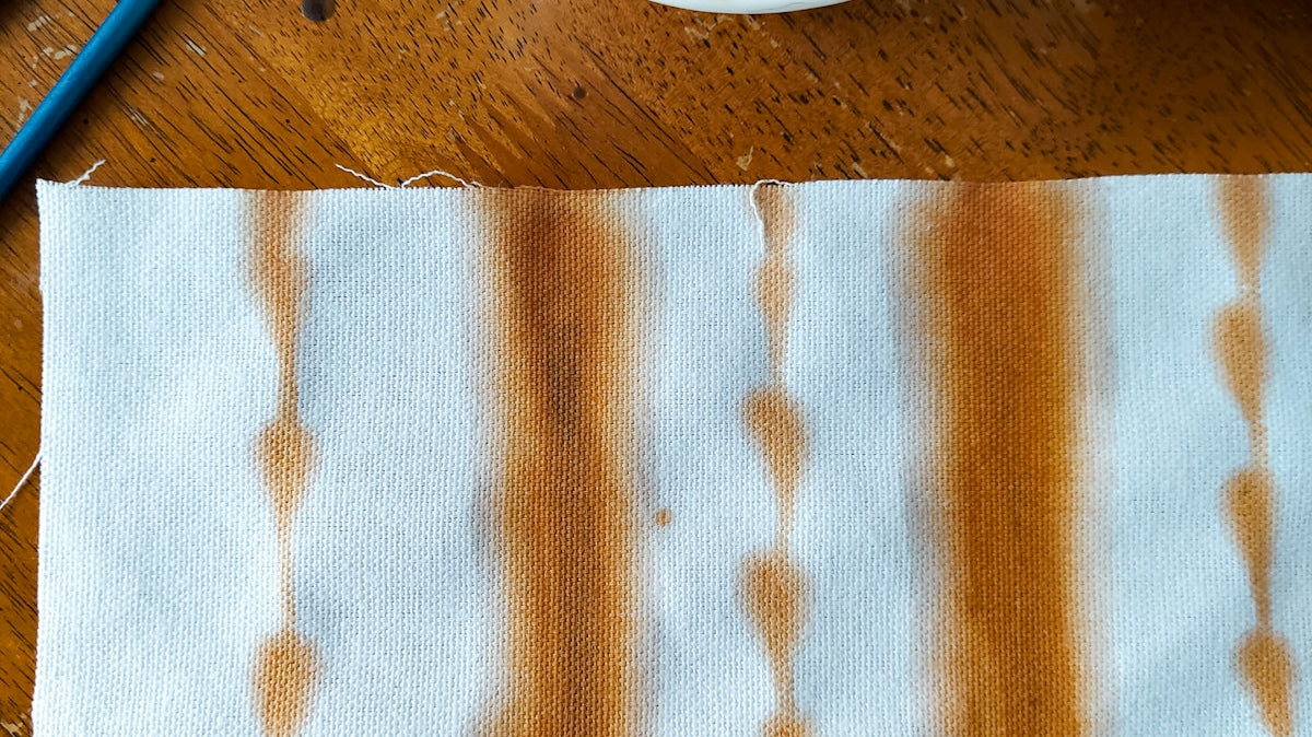a bowl of brown liquid next to a pair of scissors