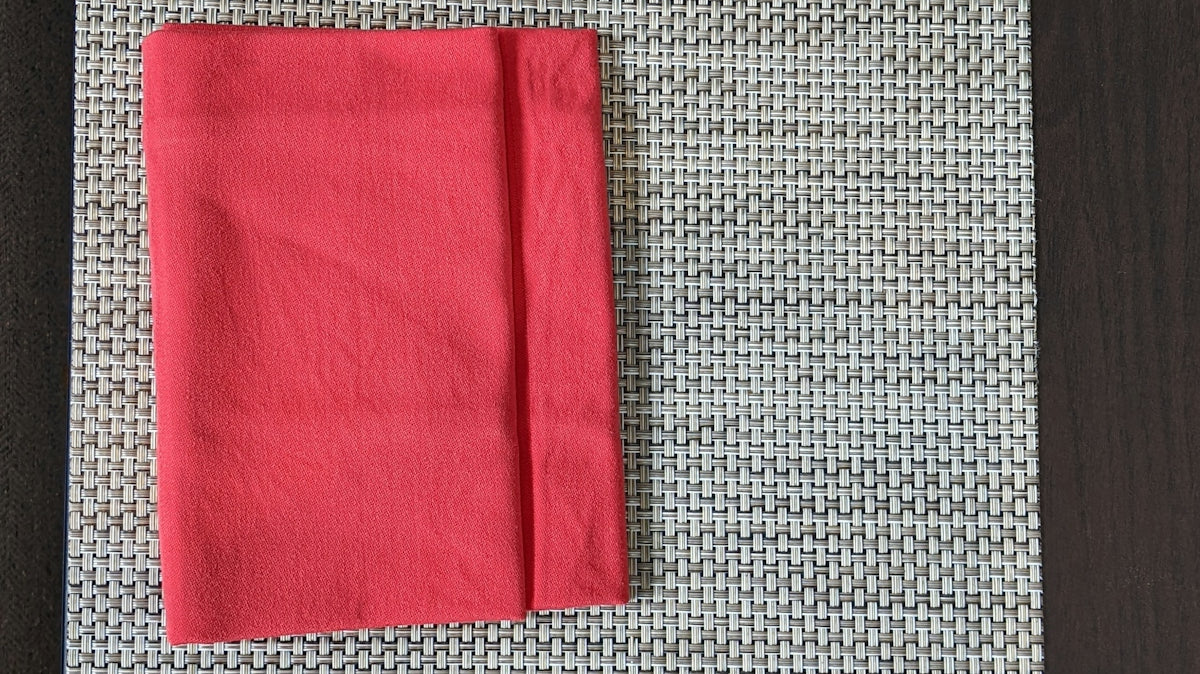 a place setting with a red napkin and silverware