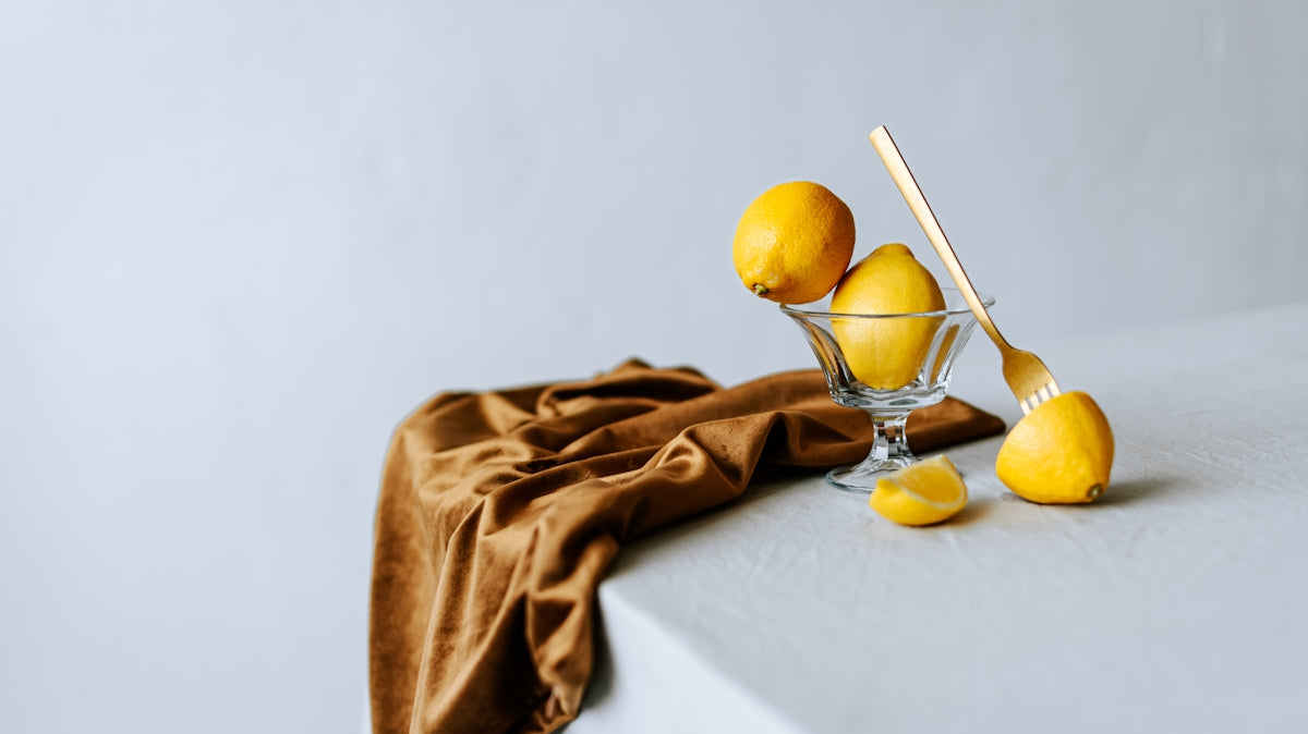 A table topped with a glass filled with lemons