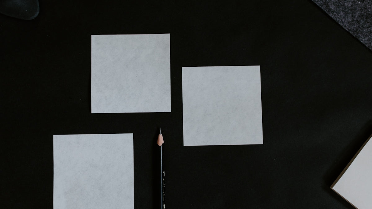 A black table topped with a pencil and paper