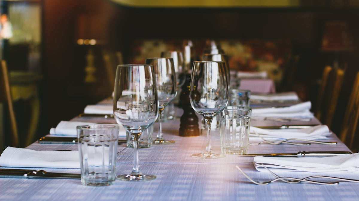 A long table with glasses and napkins on it