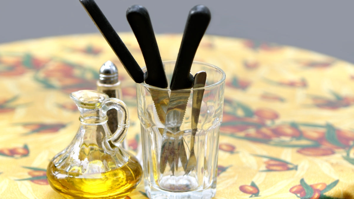 Table set with oil and utensils for a meal.