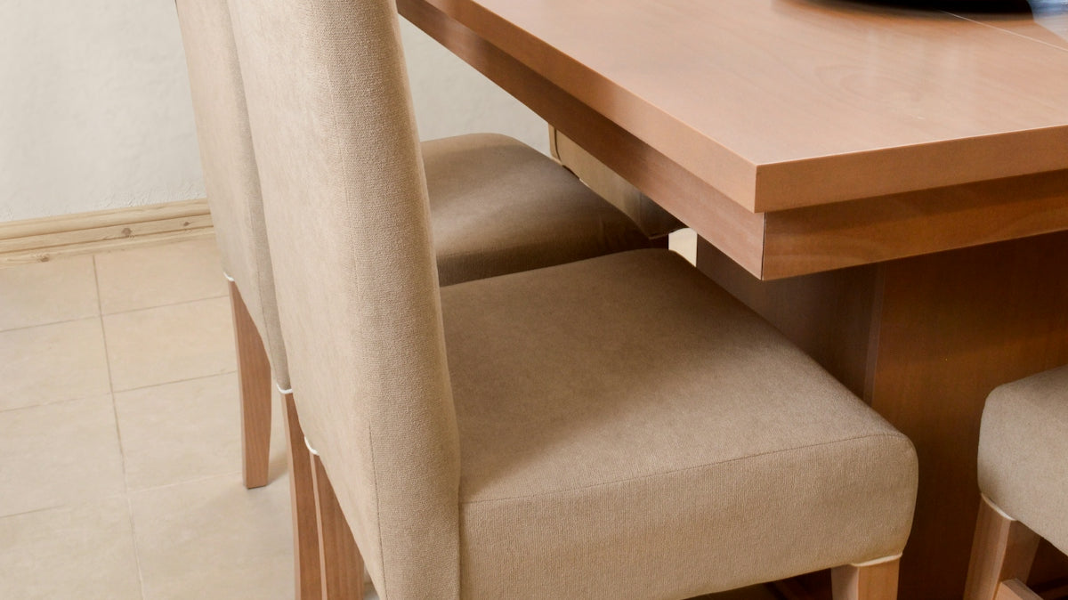 Dining table with upholstered chairs and place settings.