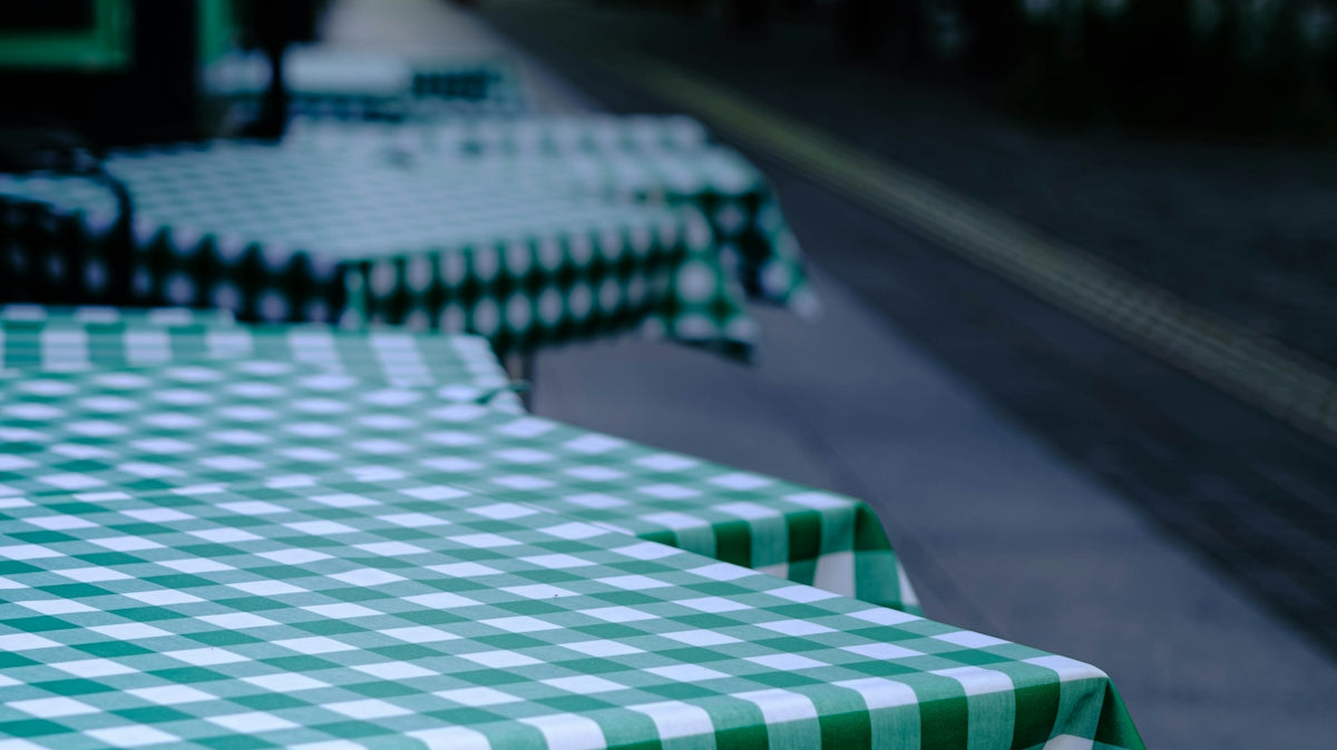 Green checkered tablecloths on outdoor cafe tables.