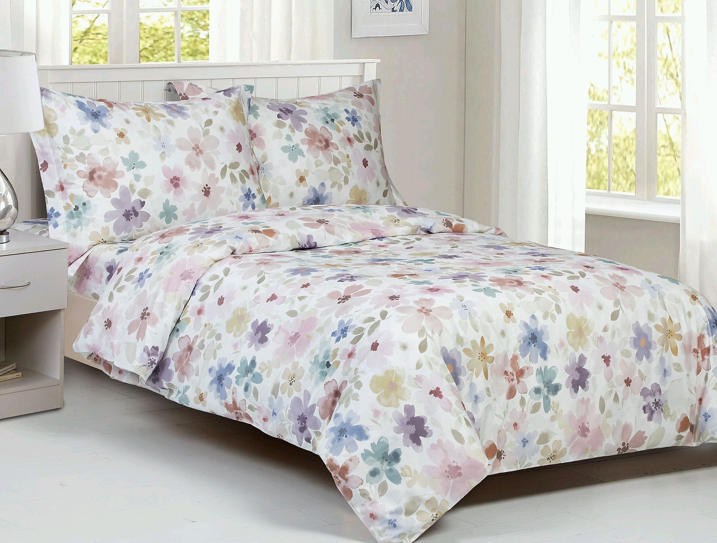 White cotton duvet set printed with soft watercolour flowers in blue, purple, pink and yellow, with two matching shams