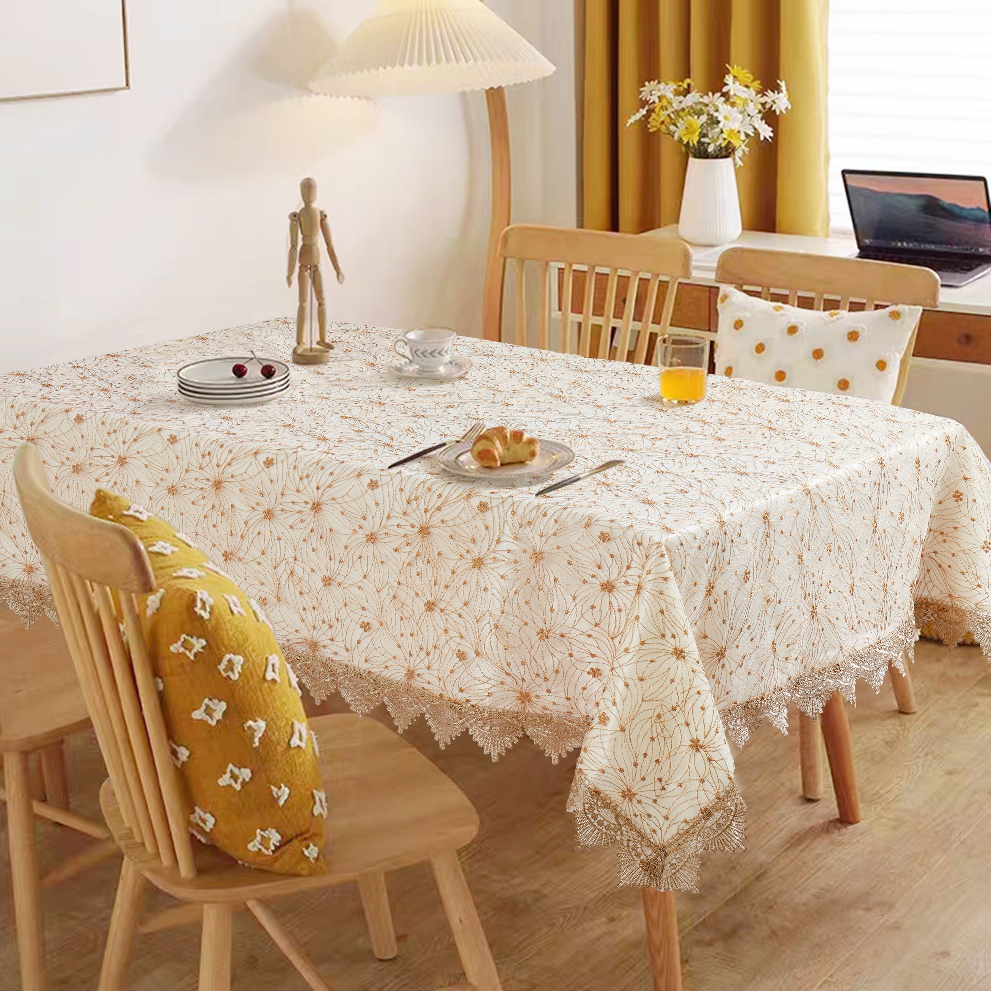 Ivory tablecloth printed with gold dandelion-burst florals and edged in scalloped lace