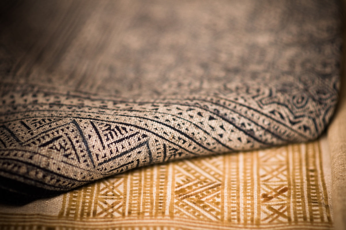 Handcrafted cotton fabric with intricate patterns in blue and beige tones.