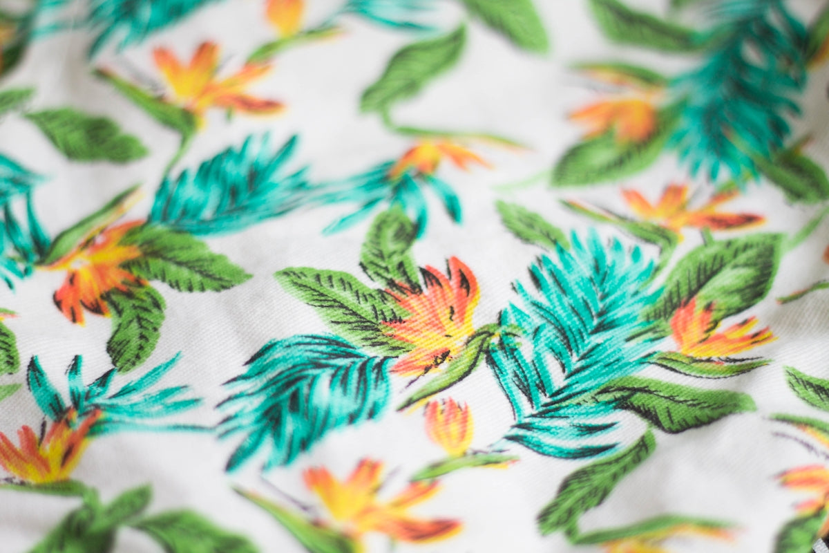 Tropical Floral Fabric featuring vibrant green leaves and colorful flowers.