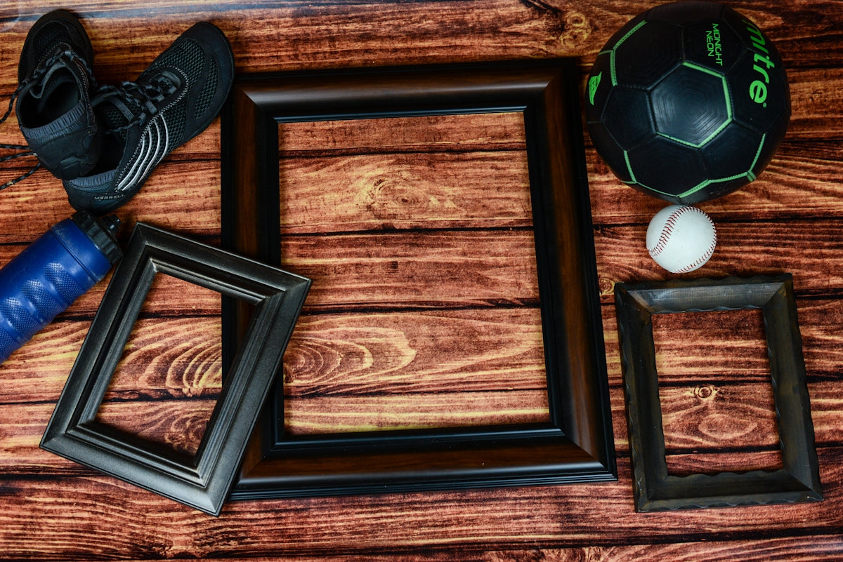 Sporting Goods Display featuring black frames, a soccer ball, baseball, and athletic shoes.