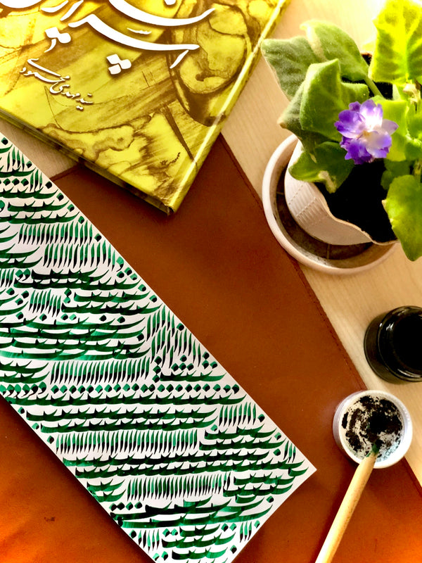 Artistic calligraphy artwork featuring green ink on paper, showcasing intricate designs.