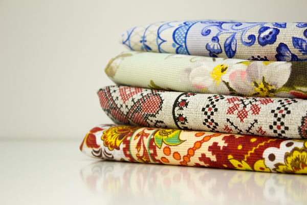 Colorful patterned fabric stack featuring floral and geometric designs.