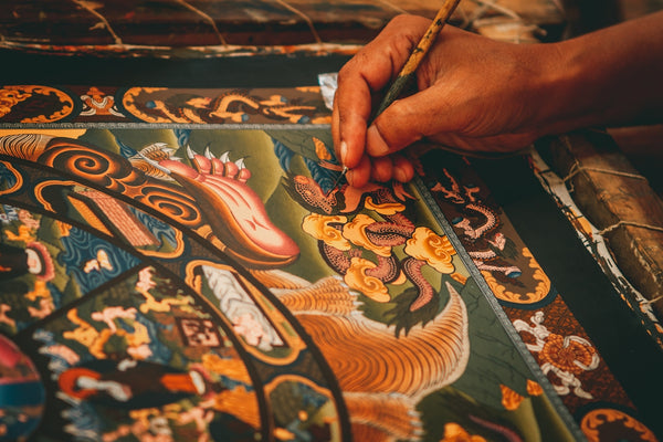 Hand-painted Tibetan thangka featuring intricate designs and vibrant colors.