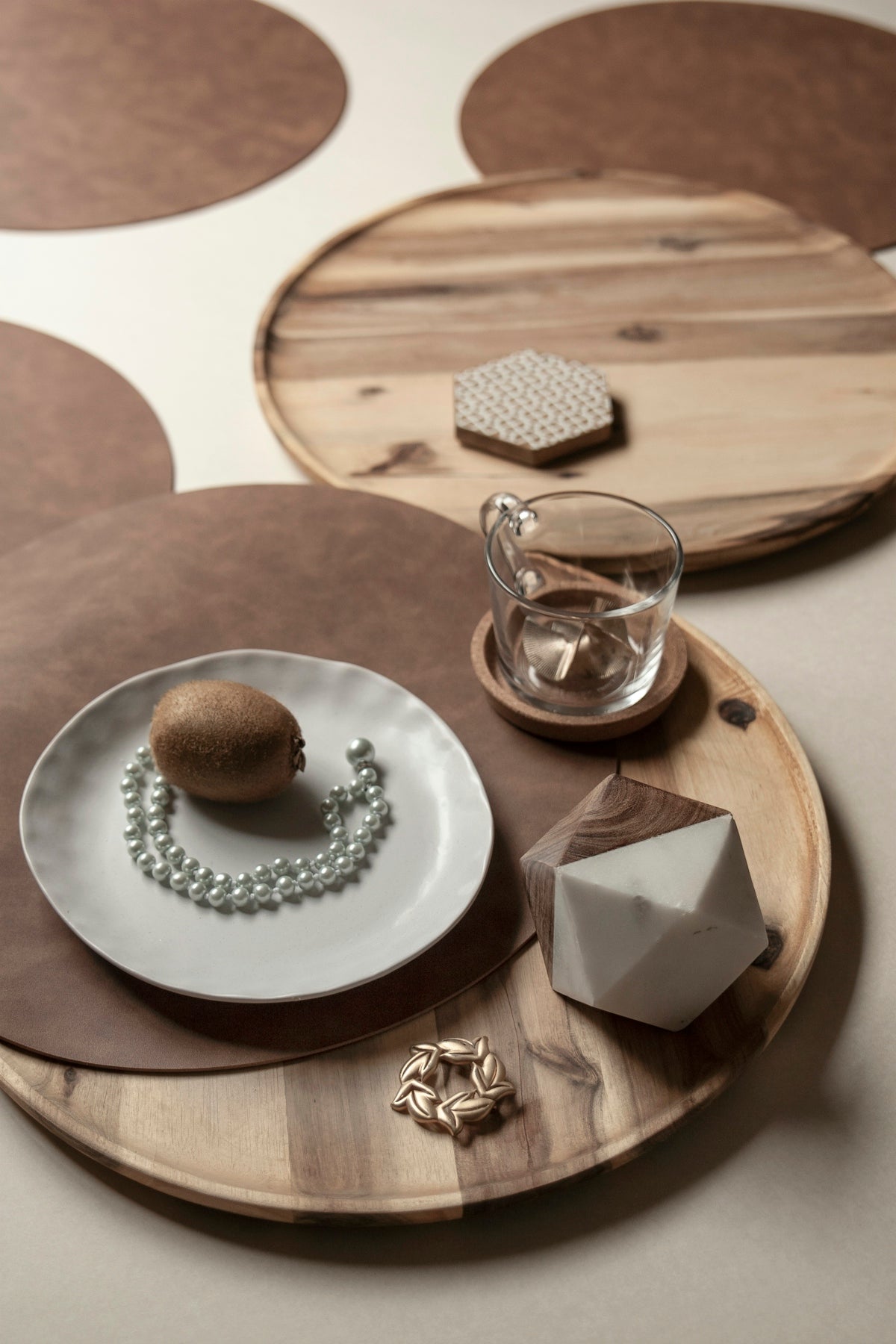 Wooden serving tray with decorative items including a plate, pearls, and a glass.