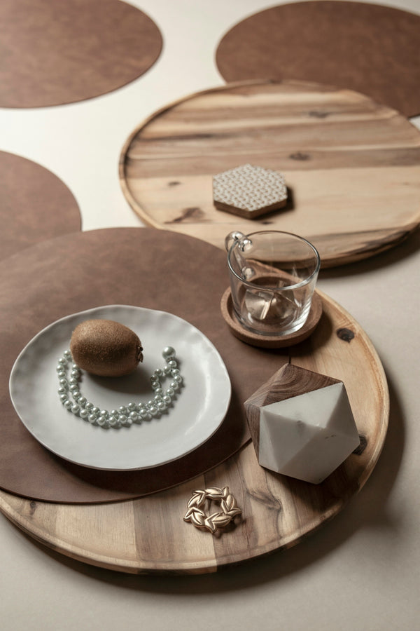 Wooden serving tray with decorative items including a plate, pearls, and a glass.