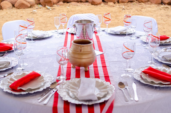 Elegant dining table setup featuring a traditional clay pot and red accents.