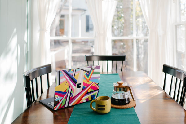 Colorful Surface Laptop on a wooden table with coffee and a tray.