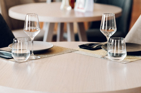 Dining table setting with elegant glassware and plates for a restaurant experience.