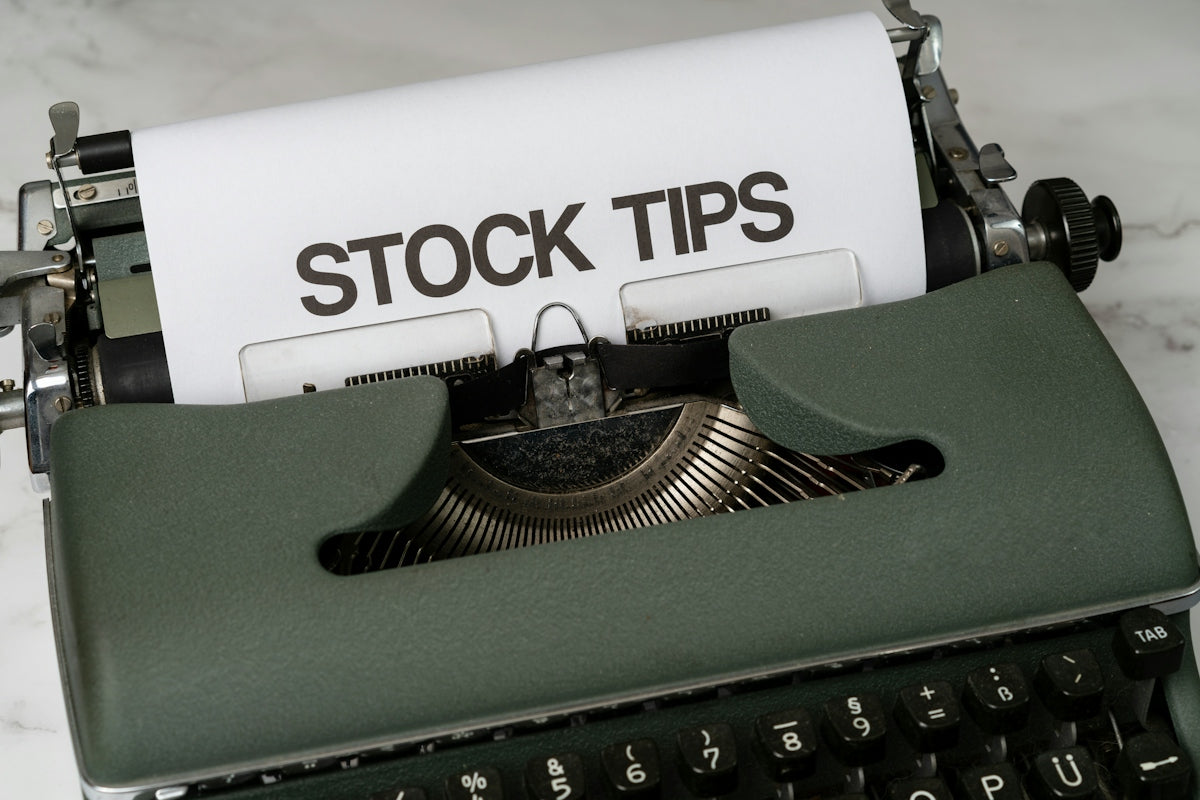 a close up of an old fashioned typewriter with a paper that reads stock tips