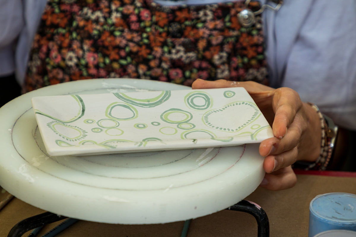 Ceramic Serving Plate with Green Bubble Design held by a person.