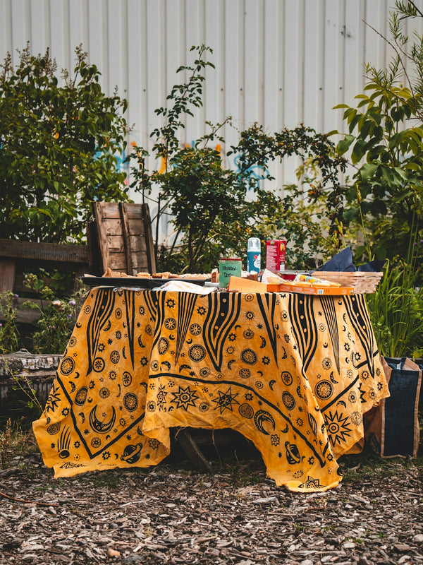 Yellow patterned tablecloth featuring intricate designs, perfect for outdoor dining.