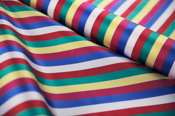 Colorful striped fabric featuring red, blue, green, yellow, and white stripes.