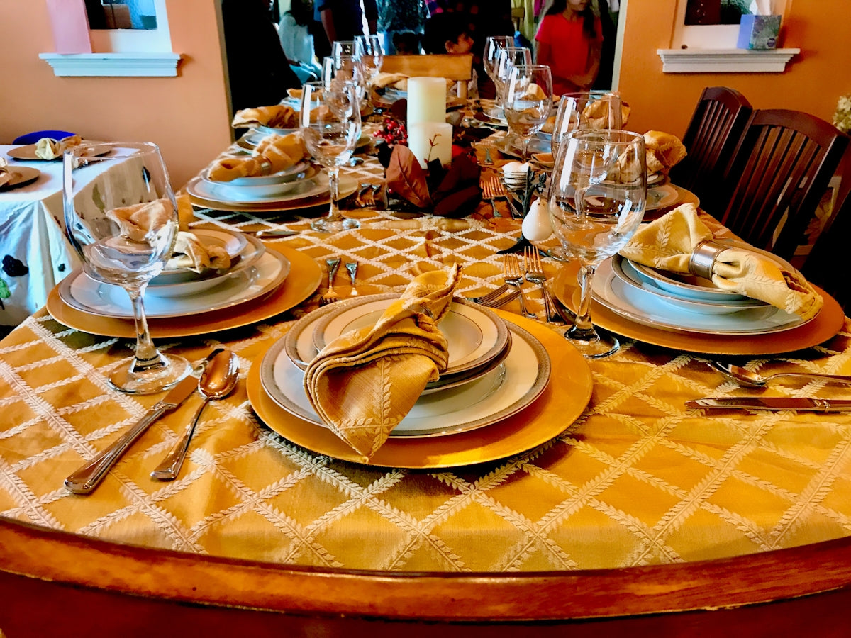 Elegant dining table setting with gold accents and fine china plates.
