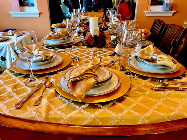 Elegant dining table setting with gold accents and fine china plates.