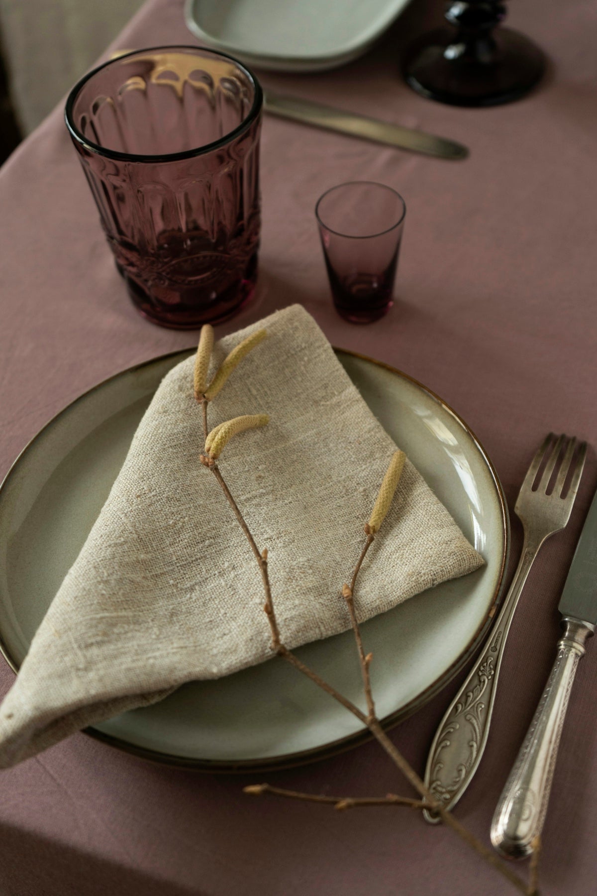 Elegant linen napkin on a plate, enhancing a stylish dining table setting.