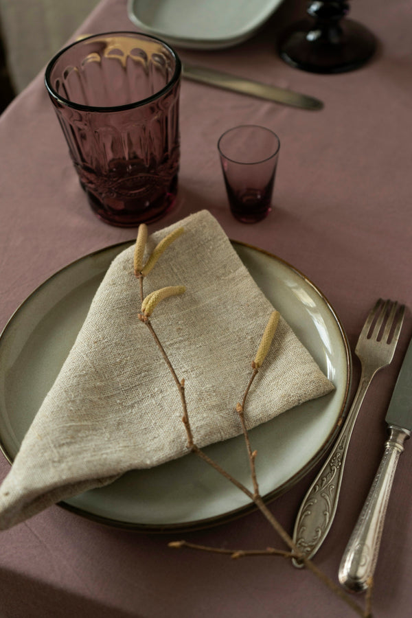 Elegant linen napkin on a plate, enhancing a stylish dining table setting.