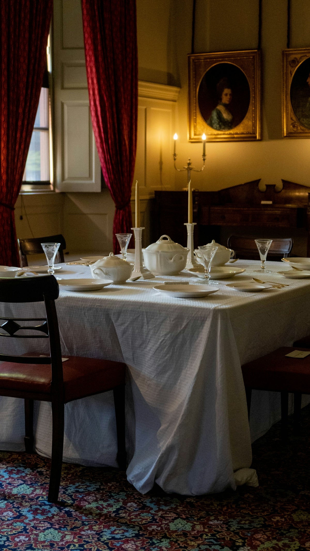 Elegant dining table setting with white tablecloth, fine china, and candles.