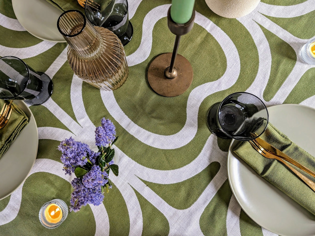 Green Abstract Tablecloth featuring a modern design with white swirls, complemented by elegant tableware.