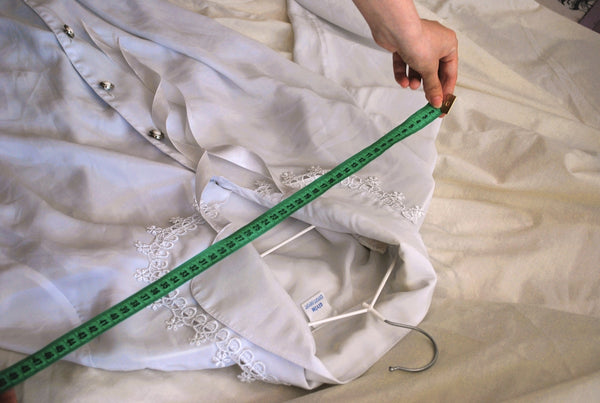 White Linen Shirt being measured with a green tape measure for size accuracy.