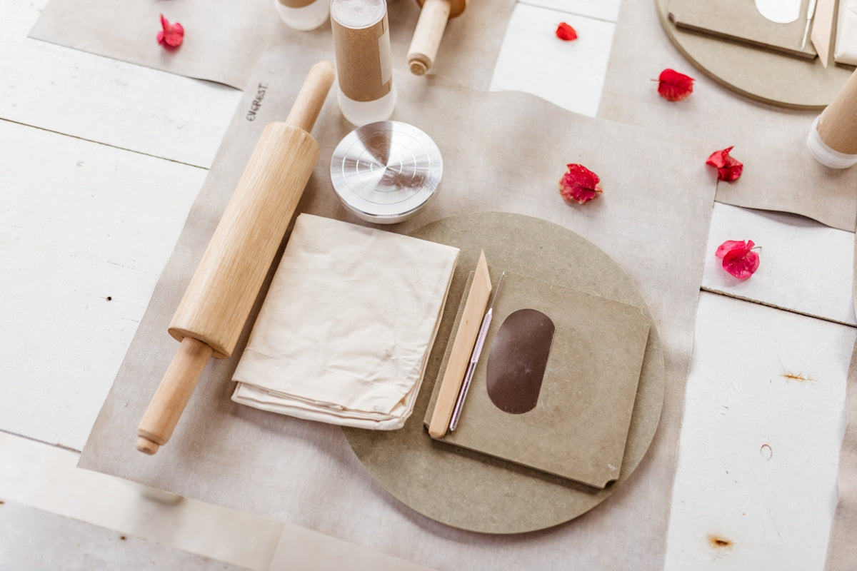 Baking set featuring a wooden rolling pin, parchment paper, and a round baking mat.