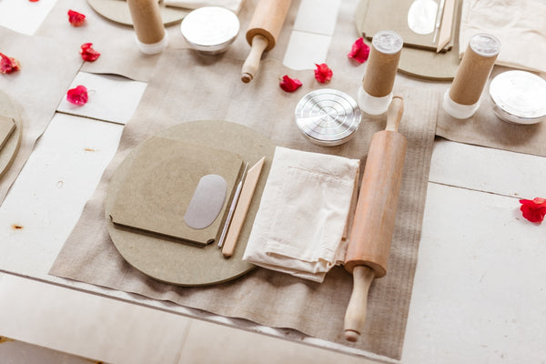 Baking set with rolling pin, dough tools, and baking mats arranged on a table.