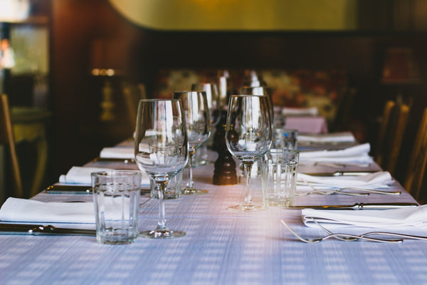 Elegant dining table setup featuring glassware and silverware for a formal meal.