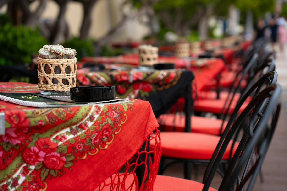 Outdoor cafe tables with red tablecloths and chairs