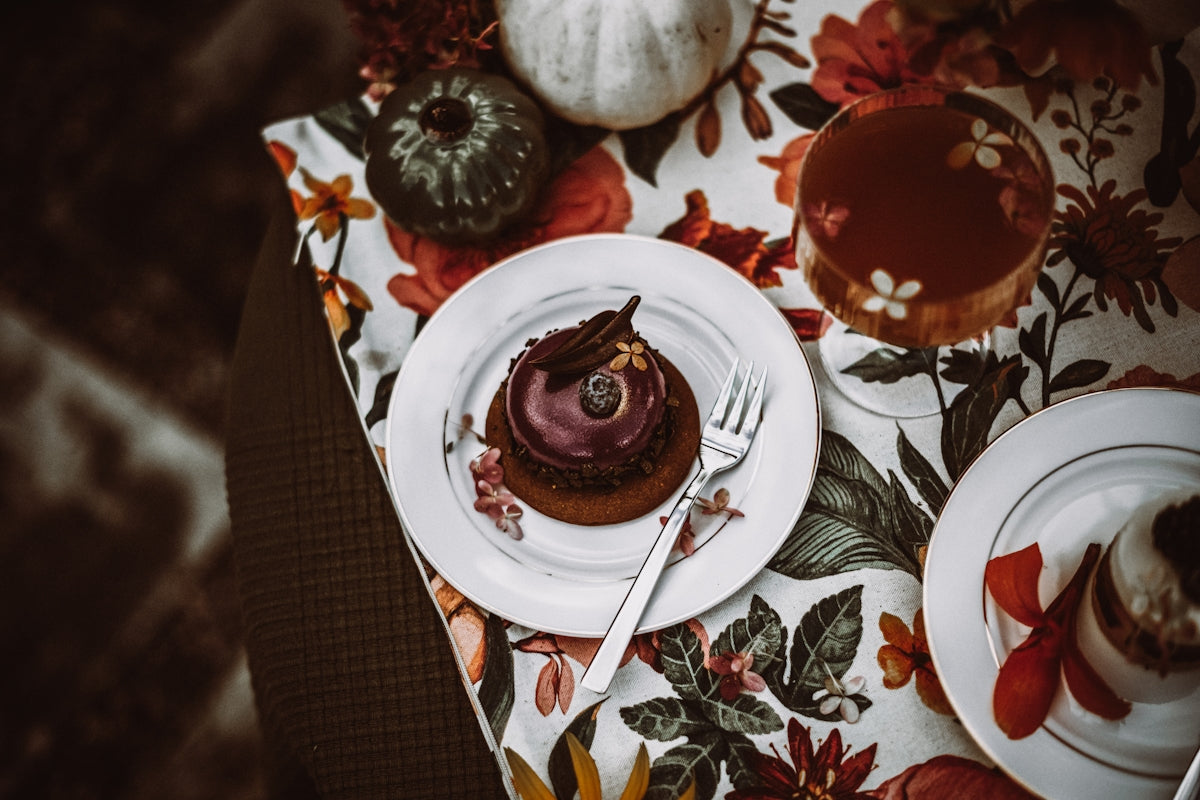 Chocolate dessert on a floral tablecloth, featuring rich frosting and decorative elements.