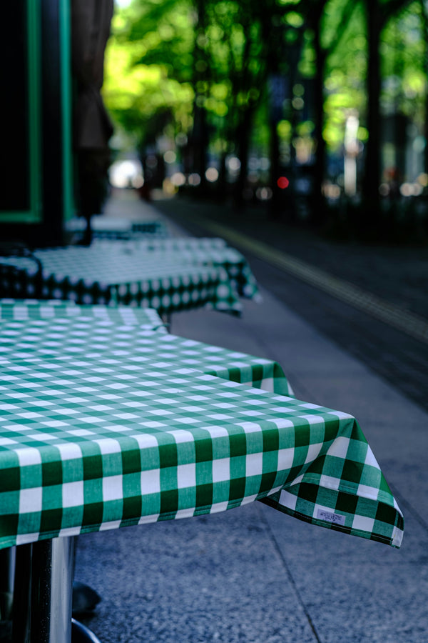 Green checkered tablecloths on outdoor cafe tables.