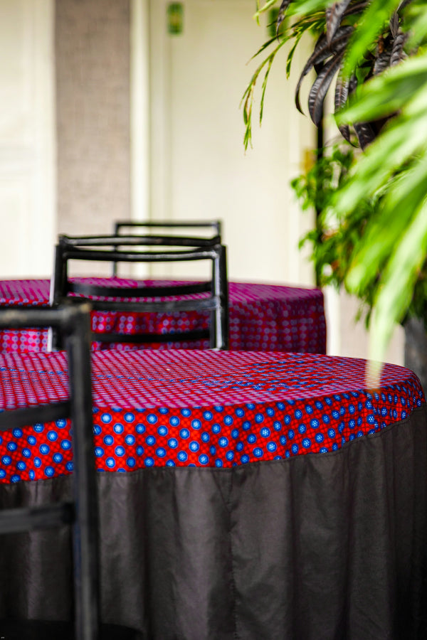 Tables with red and blue patterned tablecloths and black chairs