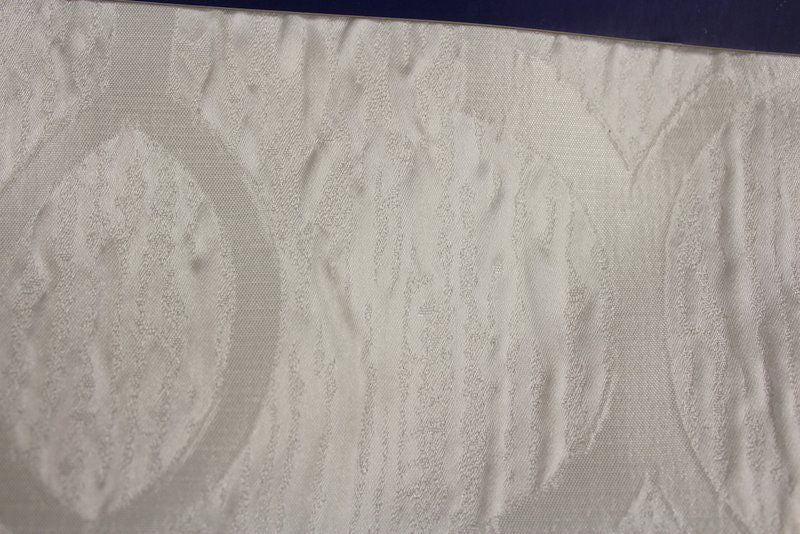 Textured white wallpaper featuring a subtle oval pattern.