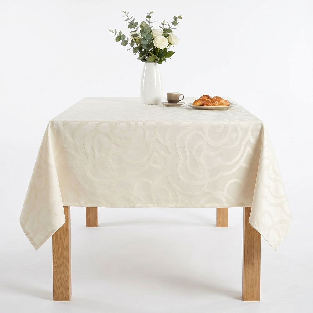 Cream Tablecloth featuring elegant swirl patterns on a dining table with a vase and pastries.