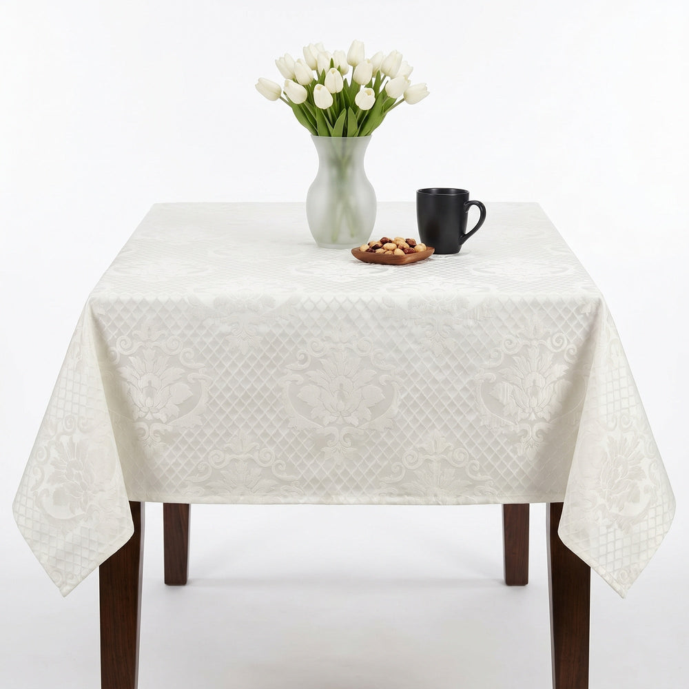 Elegant white tablecloth with intricate patterns, enhancing a dining table setting.